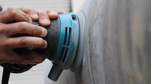 Orbital sander preparing a metal surface before polishing
