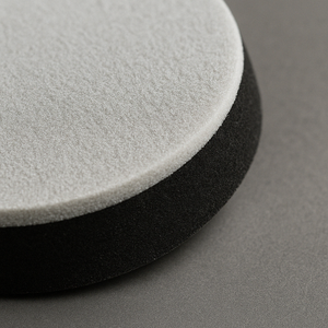 close up of 5-inch extra-thick sanding interface pads, designed for even sanding with dual-action sanders showing black foam structure and white hook and loop attachment
