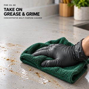 A gloved hand wipes a countertop with a green cloth in a Renegade Pine Oil 80 cleaner graphic headed Take on grease & grime.