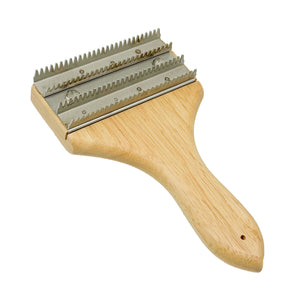 Man using a Single-Handle Buffing Wheel Rake on an orange Airway Buffing Wheel to remove metal polishing compound.