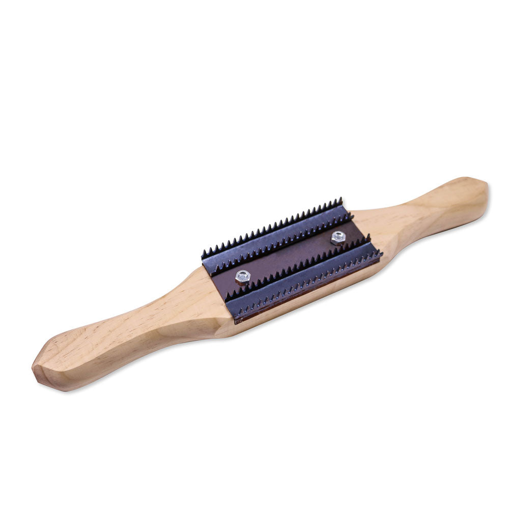 Man using a buffing wheel rake to clean and maintain an airway buffing wheel for optimal metal polishing.