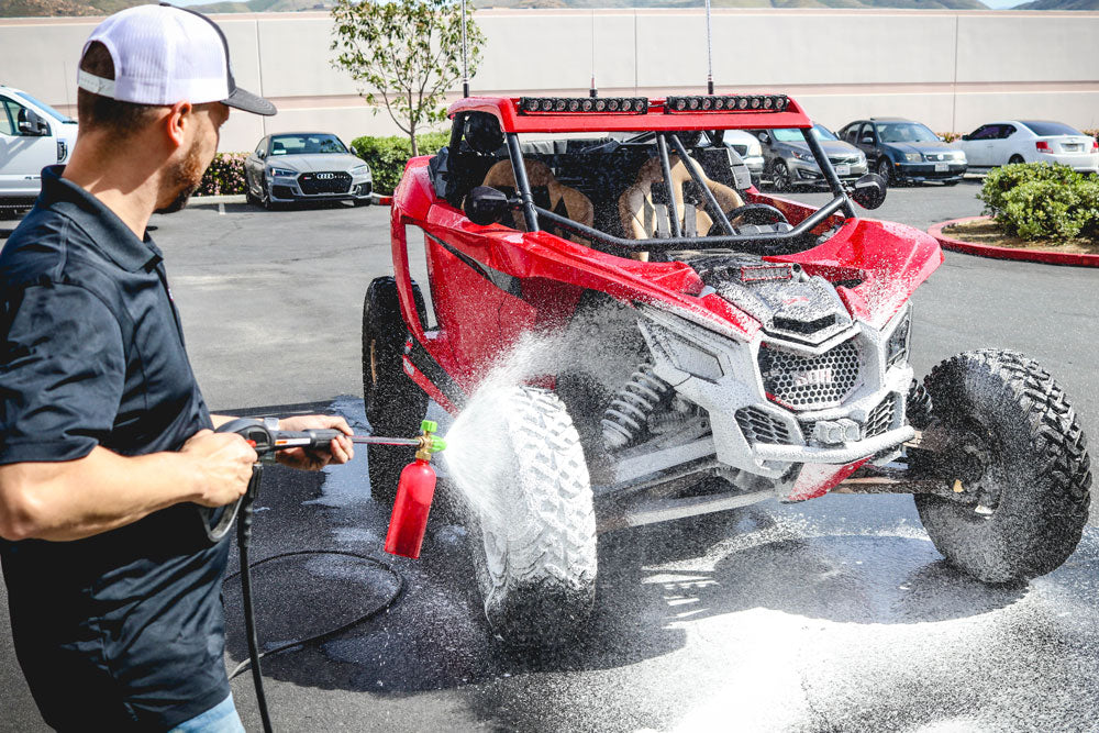 Renegade Foam Cannon in action, dispensing thick foam on a car, ideal for use with microfiber wash mitt and wheel brush.